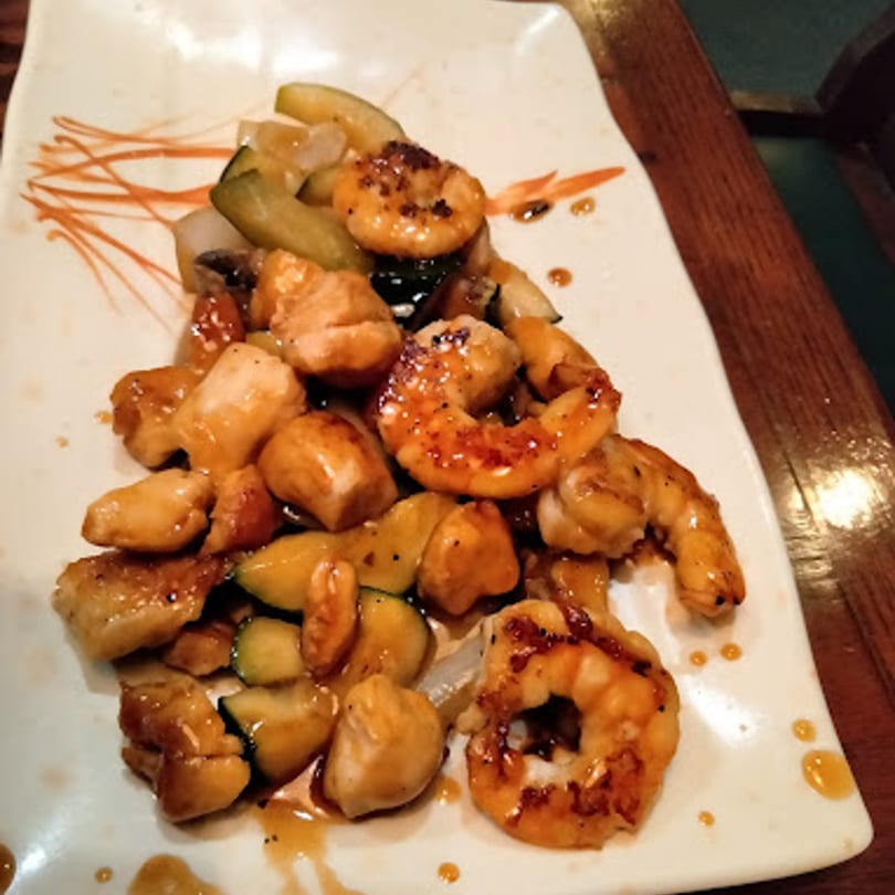 Toko Japanese Steakhouse hibachi chicken and shrimp with zucchini and onions on a white plate.